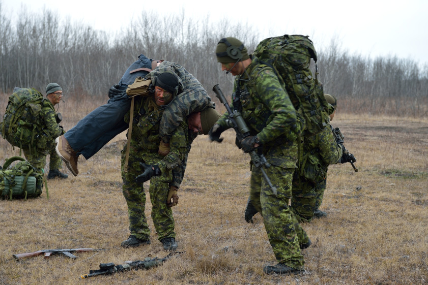 A member from 2nd Royal Canadian Regiment (2RCR) fireman carries a "gun shot" victim (role player) to safety during the Canadian Patrol Concentration (CPC) on November 17th, 2015. The Canadian Manoeuvre Training Centre (CMTC) is conducting CPC 15 in Wainwright, Alberta, November 13-24, 2015. CPC 15 will see Canadian Army Regular and Primary Reserve Force members and, for the first time, International teams deploying to the Wainwright Training Area in order to participate in a physically and mentally taxing event that will challenge their stamina, mental fortitude, section-level leadership and basic soldier skills. Image by: Corporal Jay Ekin Wainwright Garrison Imaging WT02-2015-0026-016