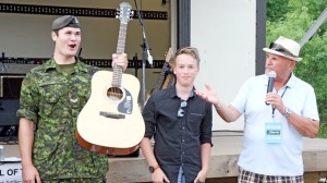 Bombardier Nolan Templeman, left, of the 56th Field Regiment was excited to receive his new instrument from the Guitars for Vets program at Saturday’s Blues for Soldiers concert. He accepted it from musician Spencer MacKenzie and Bruce Hall of the Grand River Blues Society.