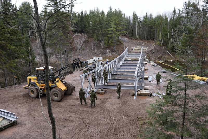 Members of 4 Engineer Support Regiment, continue the construction of the ACROW bridge spanning the Tetagouche River outside Bathurst New Brunswick as another section hangs out over the 149 foot spance to reach the 3/4 way point on 8 November 2016 during Exercise Nihilo Sapper 16. LH01-2016-025-060 Photo by WO Jerry Kean/5 Cdn Div HQ Public Affairs